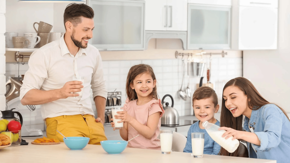 niño sonriendo mientras su familia desayuna