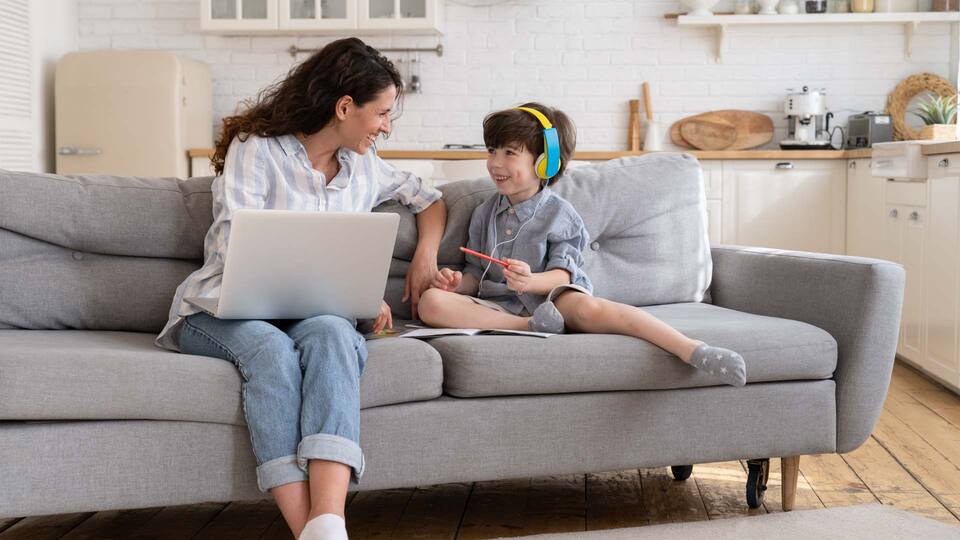 mamá con portatil sonriendoles a su hijo