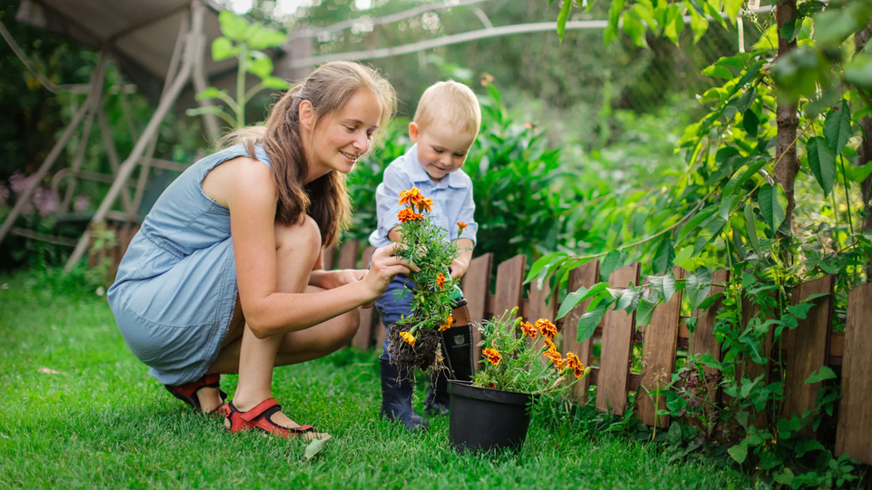 mamá enseña a su hijo a regar plantas