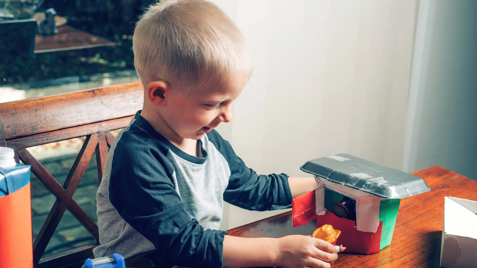 un niño construye una casa con manualidades