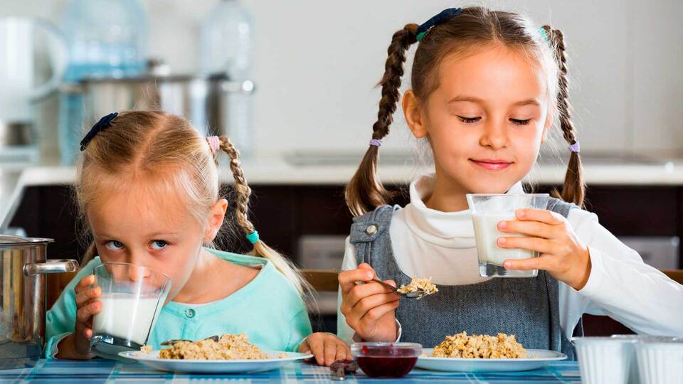 dos niñas comiendo desayuno