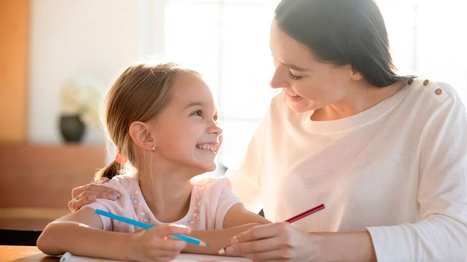 una madre enseña a su hija a dibujar