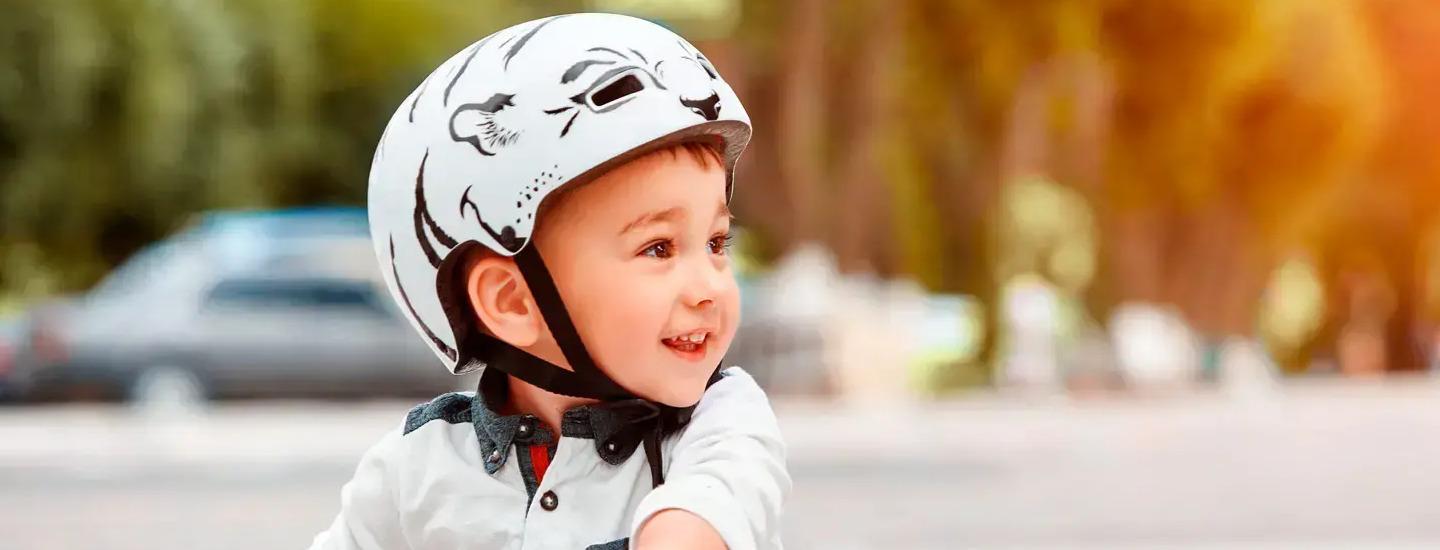 niño con casco montando monopatin