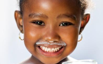 niña sonriendo con bigote de leche