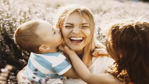 mamá sonriente mientras recibe un beso