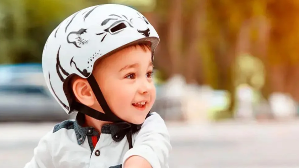 niño con casco montando monopatin