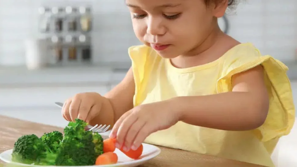 niña comiendo ensalada