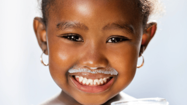niña con bigote de leche