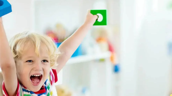 niño constryendo torre de bloques de juguete