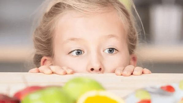 niña escondida debajo de la mesa