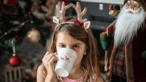 Niña tomando cafe en navidad